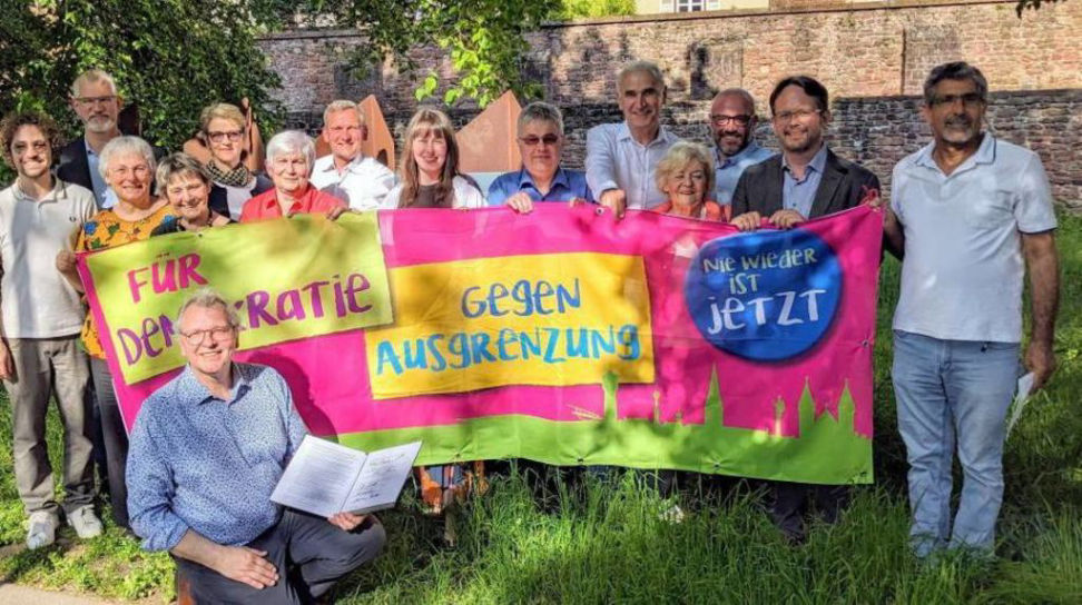 Mitglieder der Ladenburger Initiative gegen Rassismus vor ihrem Plakat