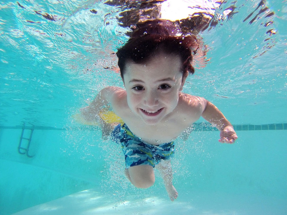 Kind mit offenen Augen unter Wasser